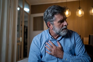Man touching his chest, wearing concerned expression