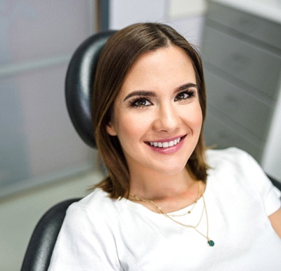 Happy woman in white shirt smiling at NightLase appointment