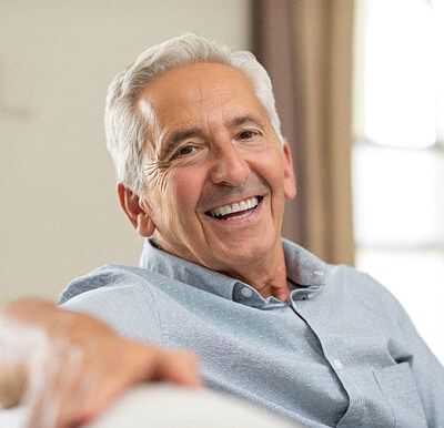 man smiling while sitting on couch