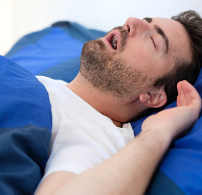 man snoring while in bed