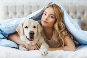 girl in bed with golden retriever