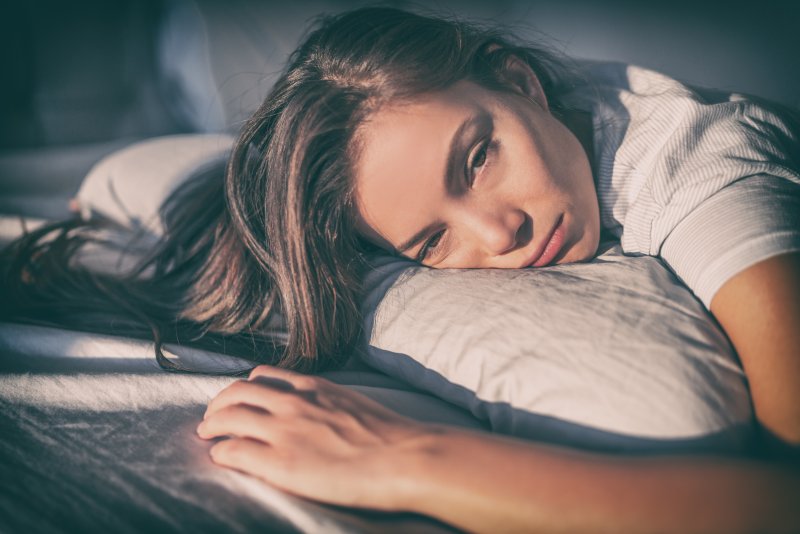 Depressed woman laying face down on pillow