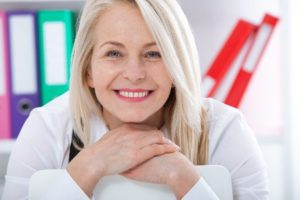 Older woman leaning on chair and smiling