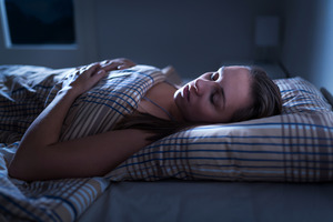 Close-up of a woman snoring in bed