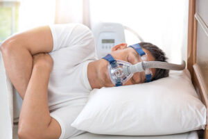 Sleeping man using CPAP machine