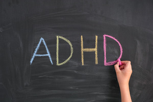 Using colored chalk to write ADHD on chalkboard