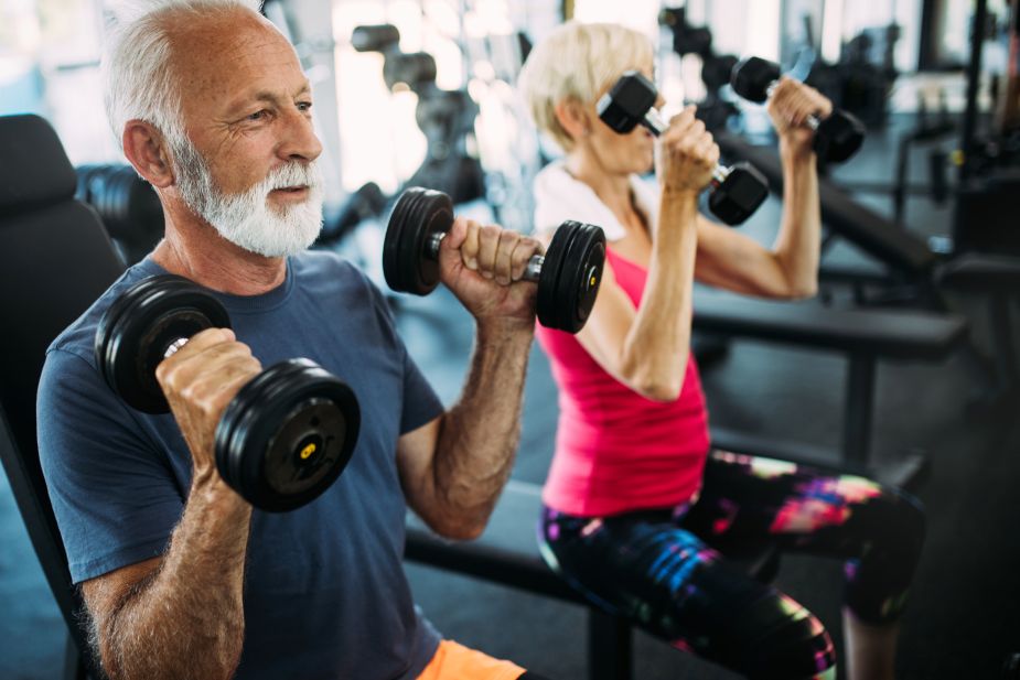 A man and woman working out at a gym.